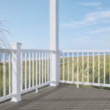 A large TimberTech deck is pictured with blue skies, a beach and the ocean in the background.
